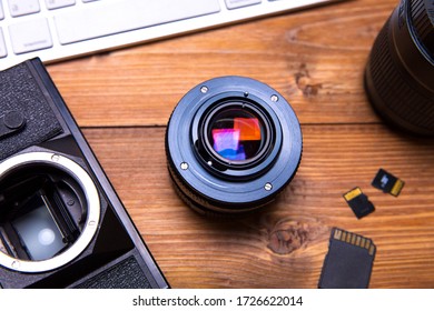 Camera lenses, camera and keyboard on the table
