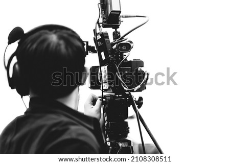 Camera man using professional video camcorder in media broadcasting industry black on white
