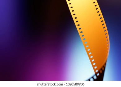 Camera Negative Film. Selective Focus On Film Perforation. Unprocessed Color Motion Picture Film. Industry Symbol For Shooting Process, Photochemical Laboratory Process And Film Archive Technology. 