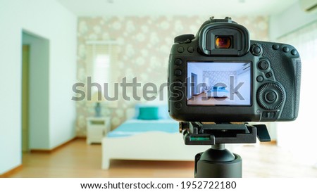 Camera on a tripod in bedroom interior, Professional dslr digital camera, selective focus, Horizontal orientation, copy space.