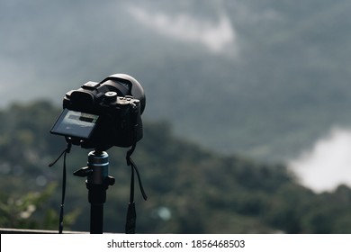 Camera on tripod making timelapse of panoramic view of mountain landscape