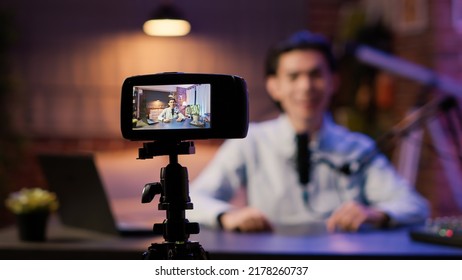 Camera On Tripod Recording Influencer Talking To Audience On Podcast Episode Show, Using Broadcasting Equipment At Audio Station. Vlogging Lifestyle Video For Entertainment Channel.