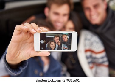 Camera Phone Showing Face Recognition Blocks Around The Faces On The Screen While A Group Of Friends Pose For A Selfie