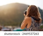 Camera, photographer and woman by mountain on vacation, travel or summer holiday in Switzerland. Dslr picture, photography and person outdoor for adventure, tourism or journey in nature in back view