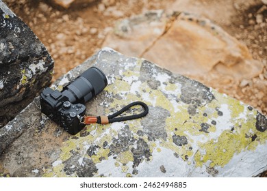 A camera is placed on a bedrock overlooking the landscape. Nearby, water flows gently beside a rock, creating a peaceful recreation spot