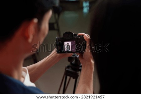 Camera screen showing model preview during photo shoot in studio