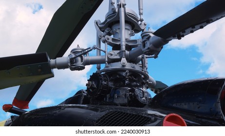 Camera slowly moves up showing a twin-rotor coaxial helicopter. Helicopter with two coaxial rotors. The main propeller of a black helicopter against a cloudy light blue sky. Coaxial helicopter blades.