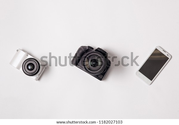 Camera, smartphone and SLR camera on white\
isolated background.