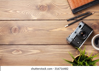 Camera and supplies on office wooden desk table. Top view with copy space - Powered by Shutterstock