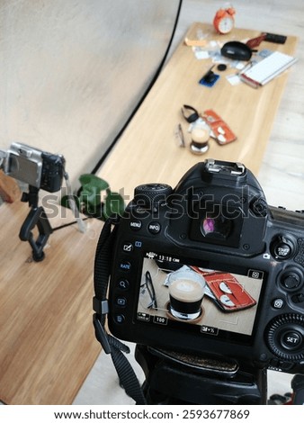 camera is taking a picture of a table with a cup of coffee and a book. The camera is on a tripod. pretag photostudio shooting screen