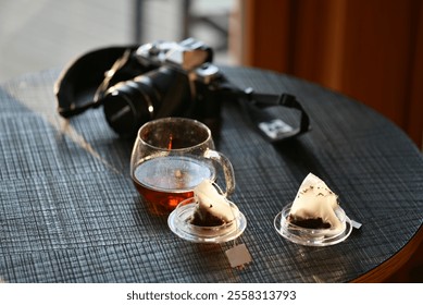 Camera and tea on the table. Everyday photos.