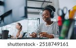 Camera view of diverse women sitting in front of computer displays. Worker on right side and wearing headset for remote consultation with clients. Working in call center. Customer support.