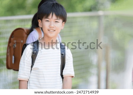 Camera view of elementary school boy with school bag on his back, close-up with copy space on the right