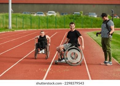 A cameraman filming the participants of the Paralympic race on the marathon course - Powered by Shutterstock