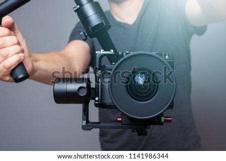 Cameraman holding gimbal with slr camera