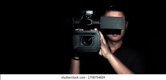 cameraman record movie with digital camera make clip in media production on dark background (banner size)
