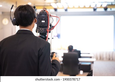 The cameraman setting up the camera for the upcoming conference