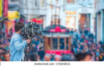 A cameraman is shooting on istiklal street on the background red Tram - Istanbul, Turkey - Shutterstock ID 1718158111