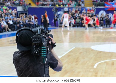 Cameraman Works At Basketball Game In Big Stadium, Back View