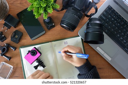 Camera's Action With Their Accessories Accompanied Of A Notebook And A Camera Reflex