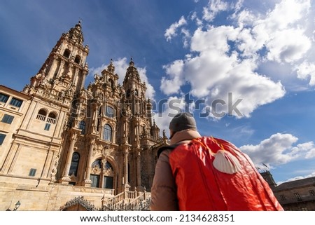 Camino de Santiago  with pilgrim woman unfocused  in Obradoiro square looking the Compostela cathedral after finishing the way of st James , Galicia, Spain