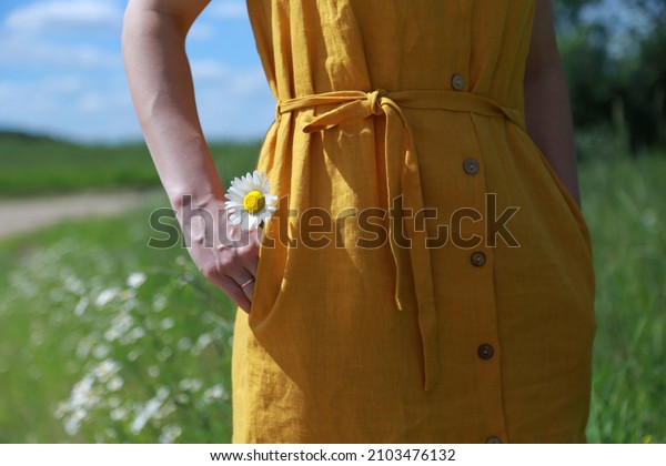 Cammomiles hidden in\
the pocket of yellow\
dress