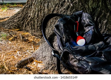 Camo Backpack Lying At The Bottom Of A Tree