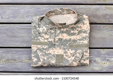 Camo Jacket On Wood. Top View, Soldiers Apparel.