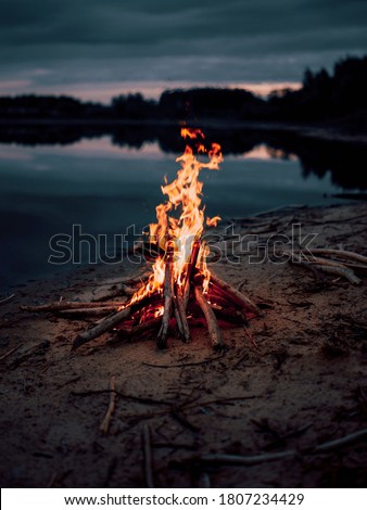 Camp bonfire near the lake .