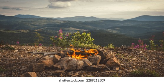 Camp fire on top of a mountain with green forest during a colorful Sunset. Taken on Carpathians Mountians. Ukraine - Powered by Shutterstock