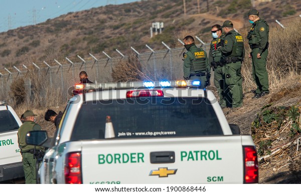 Camp Pendleton, CA  USA 12-02-2020: Border Patrol\
agents and Police detain a suspect on the side of the 5 freeway\
near Camp Pendleton Ca 
