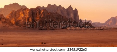 Camp site tents at Wadi Rum Desert, Jordan and red rocks sunset banner landscape
