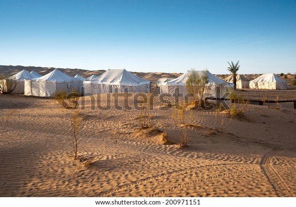 Camp of tents in a beautiful\
landscape of sand dunes in the desert of Sahara, South\
Tunisia