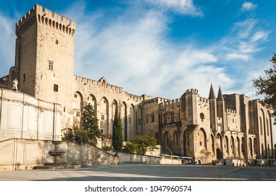 Campane Tower And Papal Palace In Avignon, France. Former Residence Of Pope In 14th Century Is The Largest Medieval Fortress And Gothic Palace Of Europe And Unesco World Heritage Site