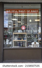 CAMPBELL RIVER, CANADA - Feb 26, 2022: A Thrift Store Window With A Mask Required Sign Advertising The Sale Of Bags Of Rags And A View Of Glasses And Cups On Shelves In The Window 