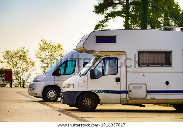 Camper cars recreational vehicle parking\
on roadside. Holidays and travel in motor\
home.