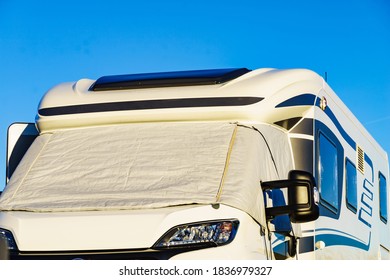 Camper with external thermal screen blind at window pane, front windscreen of the car. Camping on nature. Holidays and travel in motor home.