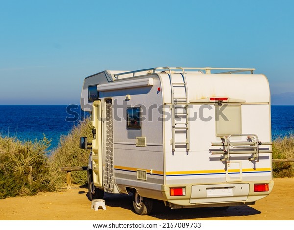 Camper,\
recreational vehicle on sea coast in Spain. Camping on nature\
beach. Holidays and traveling in motor\
home.