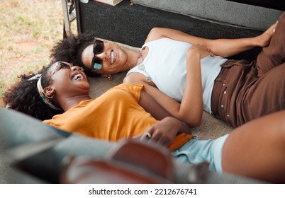 Camper, relax and friends laughing and bonding on road trip, lying in a campervan and talking. Travel, freedom and women in nature, happy while chilling in vehicle and enjoying carefree conversation - Powered by Shutterstock