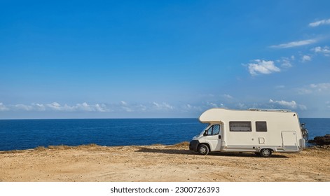 Camper rv caravan on mediterranean coast in Italy. Wild camping on sea shore. Holidays and travel in motor home. - Shutterstock ID 2300726393