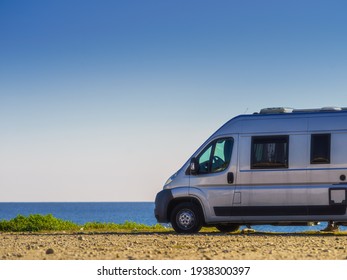 Camper rv van on mediterranean coast in Spain. Wild camping on beach. Holidays and travel in motor home.