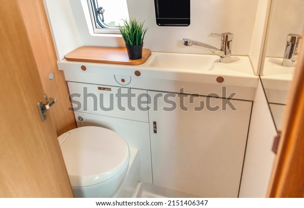 Camper van\
bathroom interior with toilet and\
sink