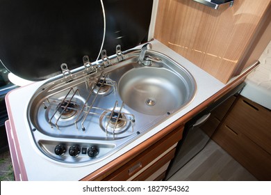 Camper Van Interior With The Small Kitchen With Gas Stove Fire And Sink