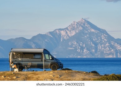 Camper van parked by the sea with a stunning view of Mount Athos in the background, capturing the essence of adventure and outdoor living in Greece. - Powered by Shutterstock