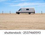 Camper van parked on the sand of an unspoiled beach on a beach in Spain.