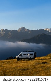 Camper van parked overlooking a cloud inversion and mountains at sunrise in Superbagneres