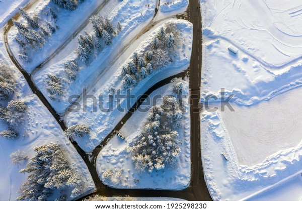 Camper van parked in a snowy winter landscape.\
Aerial view.