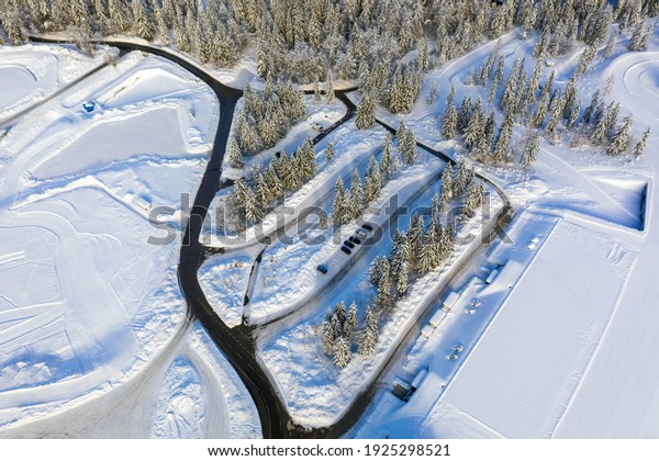 Camper van parked in a snowy winter landscape.\
Aerial view.