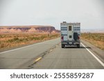 Camper Van, RV, on a US-American Highway  surrounded by Desert an Mountains, Landscape, Copy Space