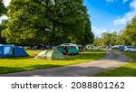 Camper vans and tents pitched at Cobleland Campsite during the summer in Trossachs National Park, Scotland